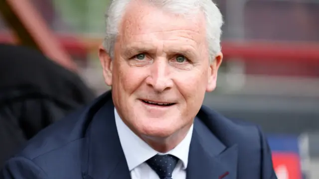 Mark Hughes smiling in the dugout