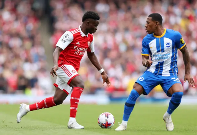 Bukayo Saka of Arsenal runs at Pervis Estupinan of Brighton