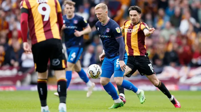 Carlisle and Bradford players challenge for the ball