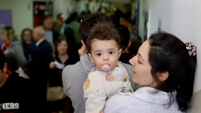 A mother takes a young child to vote