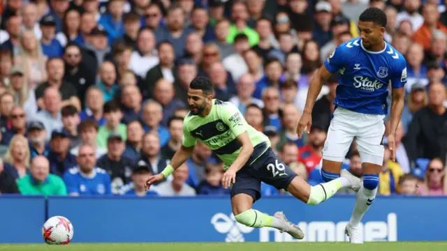 Riyad Mahrez of Manchester City is challenged by Mason Holgate of Everton