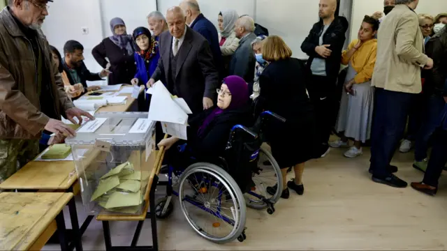 A woman who uses a wheelchair casts her vote