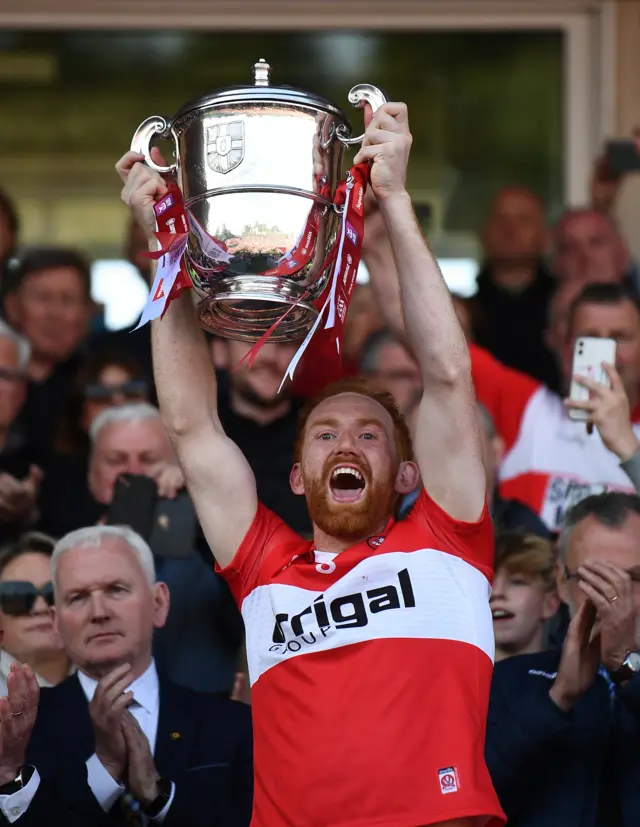 Derry captain Conor Glass lifts the trophy