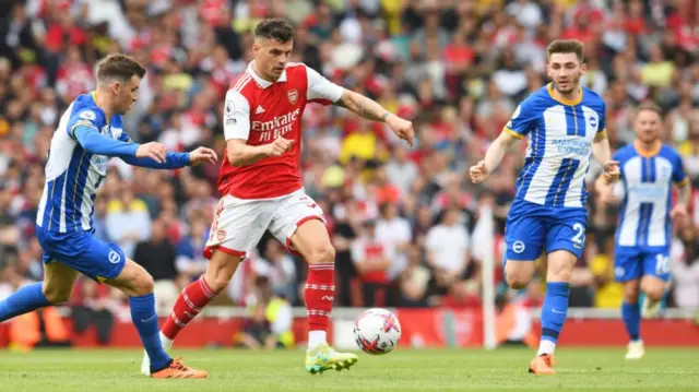 Granit Xhaka of Arsenal controls the ball while under pressure from Pascal Gross of Brighton