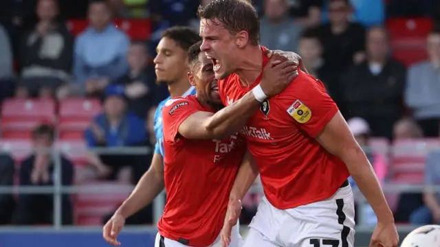 Matt Smith celebrates putting Salford ahead in their League Two play-off semi-final first leg against Stockport