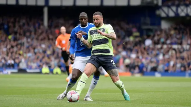 Abdoulaye Doucoure of Everton and Manchester City's Kyle Walker challenge for the ball