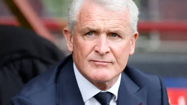 Mark Hughes sits in the dugout