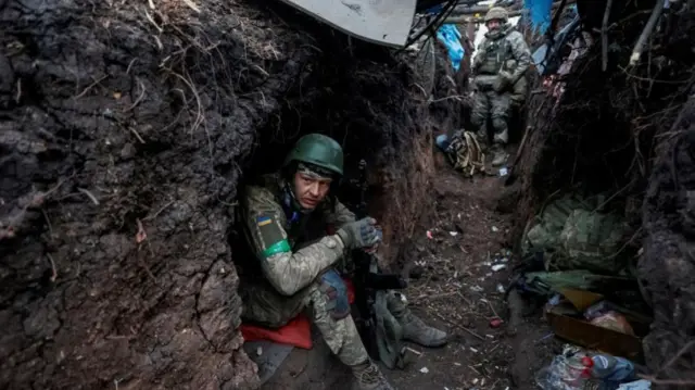 Ukrainian soldiers rest at their positions after a fight near the front line city of Bakhmut, Donetsk region, on 11 May