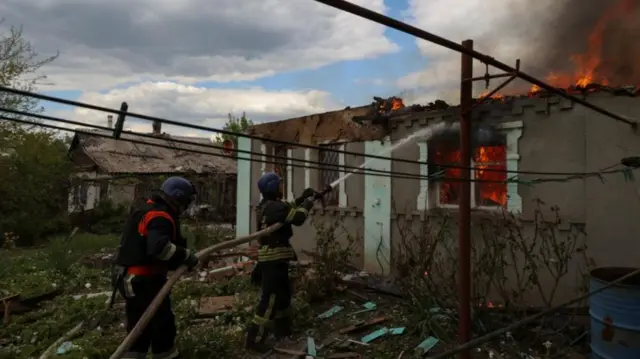 Firefighters work to extinguish a burning residential house after a Russian military strike in Kostyantynivka, Donetsk region on 12 May