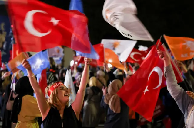 A supporter of Turkish President Tayyip Erdogan waves flags outside the AK Party headquarters