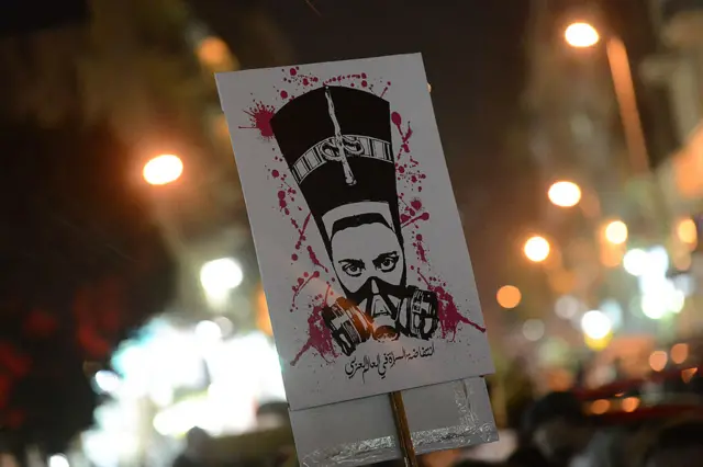 A protestor holds a placard with a slogan "The uprising of women in the Arab world" during a demonstration against sexual harassment in Cairo on February 12, 2013.