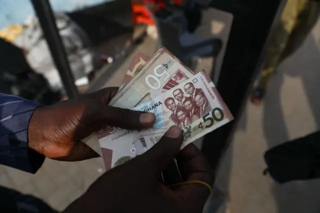 A man holds a 50 cedis, the Ghana currency, note in Accra, Ghana, on December 1, 2022. - Ghana is battling its worst economic crisis in decades.