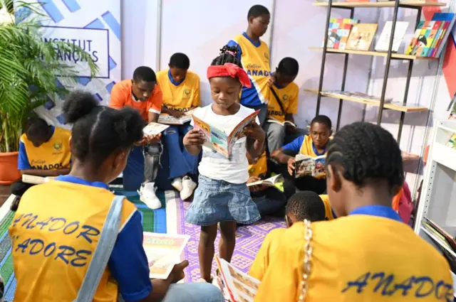 School children read during the Abidjan International Book fair in Abidjan on May 13, 2023.