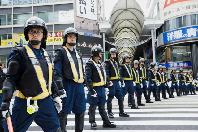 Police officers stand guard during a protest against the G7 summit in Hiroshima