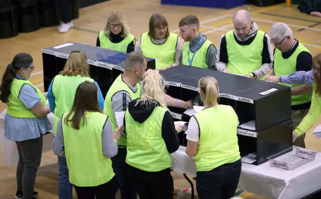 Count centre staff in high vis jackets sort through ballots