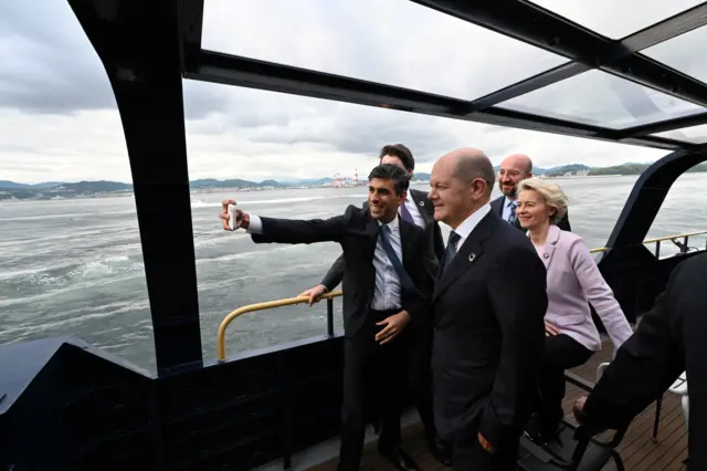 UK PM Rishi Sunak takes a selfie as the leaders board a ship toward to the Itsukushima Shrine