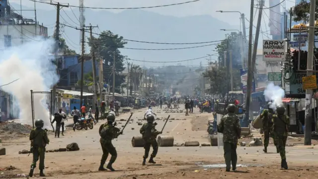 Riot police officers lob teargas canisters to disperse supporters of Kenya's opposition leader Raila Odinga of the Azimio La Umoja (Declaration of Unity) One Kenya Alliance, during protests over cost of living and Kenya