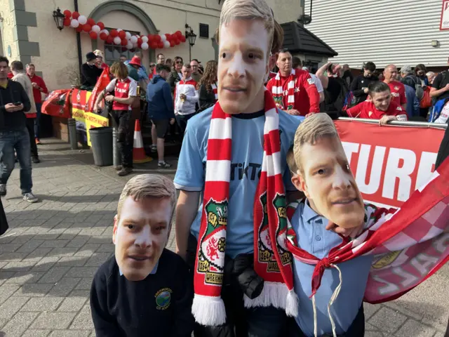 Young Wrexham fans in Paul Mullin masks outside the Turf