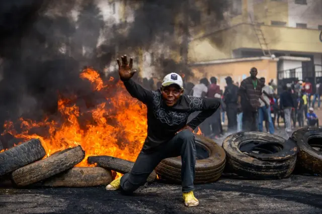 A supporter of opposition coalition protest over high living costs and alleged fraud in last year's election in front of burning tyres in Nairobi, Kenya 2 May 2023