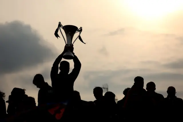 Outline of person holding trophy