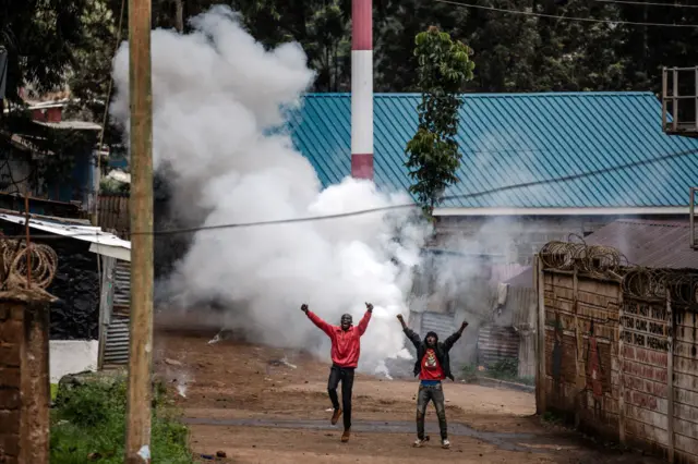 Opposition supporters react after a teargas canister was shot by Kenyan police officers during riots in the informal settlement of Kibera in Nairobi - 2 May 2023