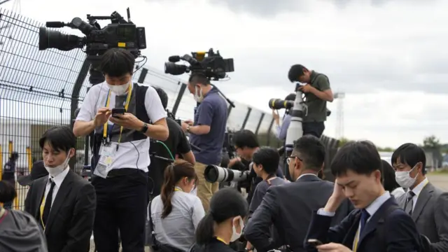 Members of the media wait for the plane carrying Ukrainian President Volodymyr Zelensky to arrive outside the Hiroshima airport