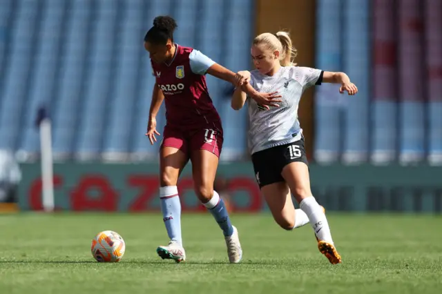 Villa and Liverpool players battle for the ball.