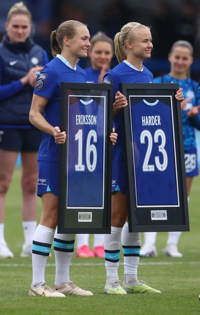 Eriksson and Harder hold commemorative shirts in frames.