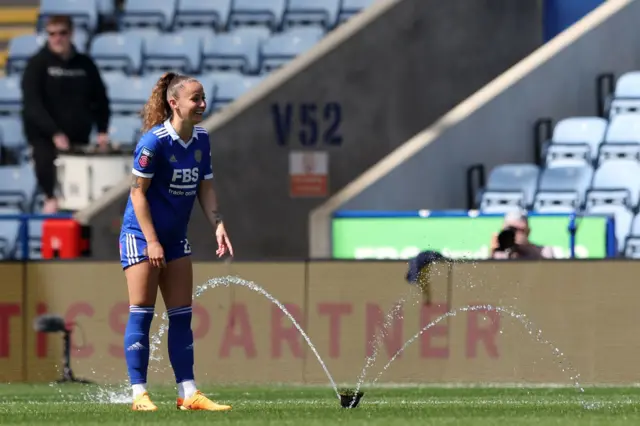 The sprinklers interrupt play at the King Power.