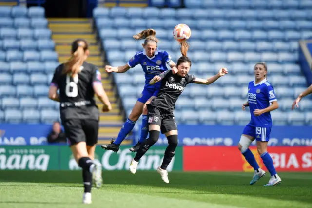 Whelan and Shimizu compete for the ball in an aerial duel.