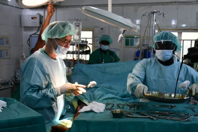 A surgeon is seen at work on a patient with a bullet wound at the main hospital in Maiduguri on January 25, 2022