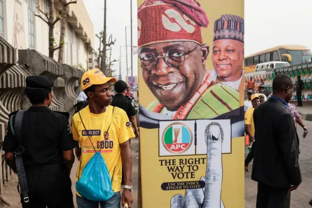 A man walks past campaign posters of All Progressive Congress (APC) leader, Bola Tinubu, outside the Teslim Balogun Stadium in Lagos on February 21, 2023