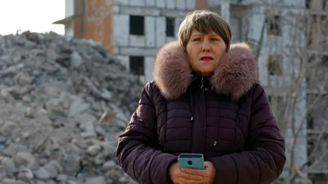Tatiana Bushlanova, 65, stands next to the ruins of her apartment block, demolished due to heavy damage received in the course of Russia-Ukraine conflict in Mariupol, Russian-controlled Ukraine, February 5, 2023