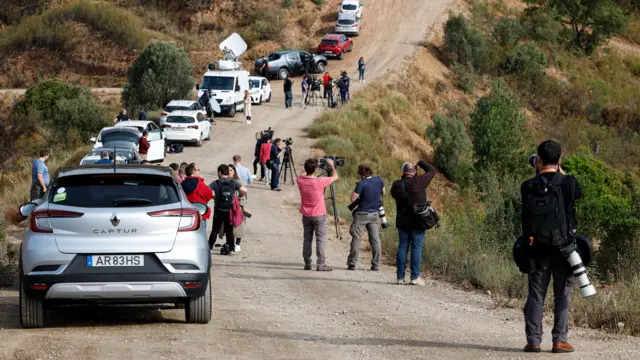 Members of the news media on the field near the makeshift base camp of the criminal investigation unit in the Arade dam area