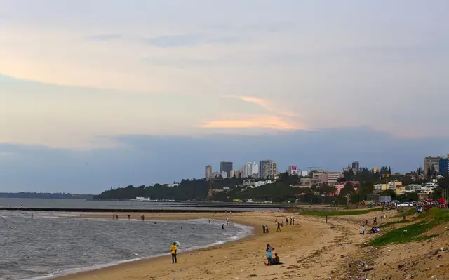 People walk on a beach in Maputo on January 10, 2014.