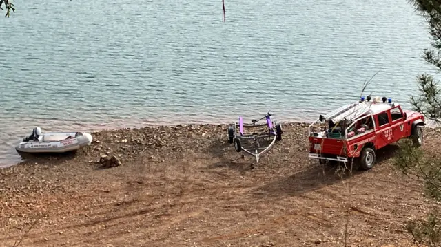 The search team have launched a small inflatable boat on the rocky shore of the reservoir as they begin the search for Madeleine McCann