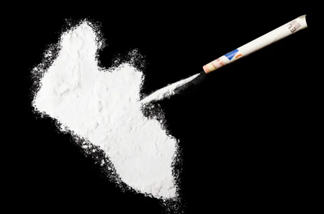 A top shot of a powder drug like cocaine in the shape of Liberia (stock photo)