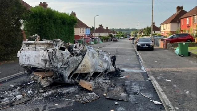 A burnt out and overturned car