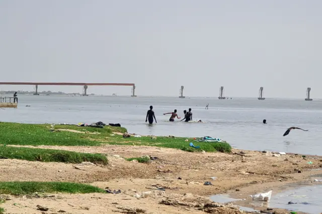 Youths swimming  in the White Nile near the al-Dabbasin bridge in Sudan's capital, Khartoum - 23 May 2023