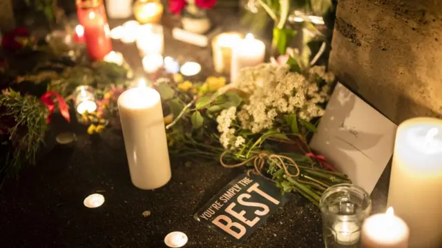 Flowers, candles and cards - including one reading "you're simply the best"