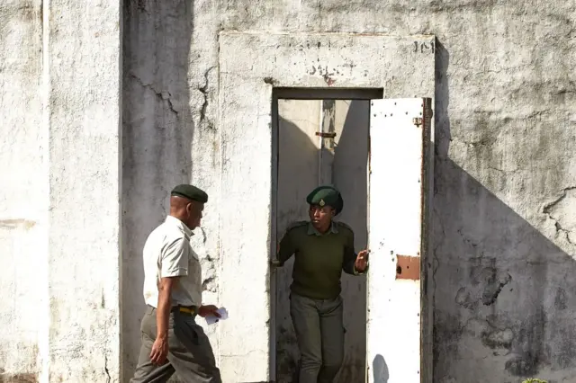 A guard with the Zimbabwe Prisons and Correctional Service (ZPCS) looks on ahead the release of inmates from Harare Central Prison on May 19, 2023.