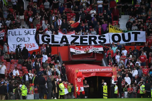 Banner reading 'Glazers out' in front of the Old Trafford tunnel