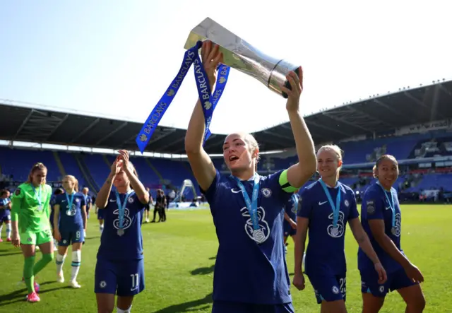 Magda Eriksson lifts the WSL trophy in front of the Chelsea fans.