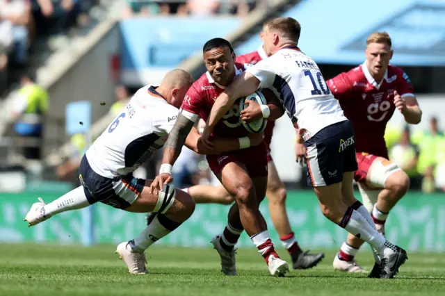 Sale centre Manu Tuilagi is tackled by Owen Farrell