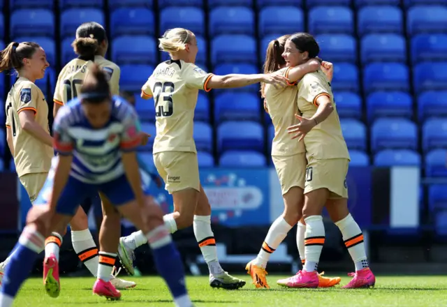 Chelsea players celebrate together as Reading defenders slump to their haunches.