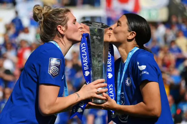 Millie Bright and Sam Kerr of Chelsea kiss the Barclays Women's Super League trophy after the team's victory during the FA Women's Super League match between Reading and Chelsea at Select Car Leasing Stadium on May 27, 2023 in Reading, England