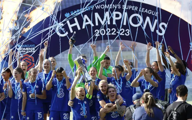 Chelsea captains lift the WSL trophy aloft on the official podium.