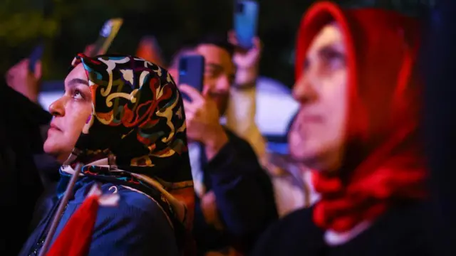 Supporters of Turkish President Tayyip Erdogan watch his address on a screen after the presidential election, in Istanbul, Turkey May 29, 2023.