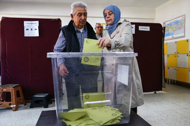 A woman casts her ballot as she votes at a polling station in Ankara