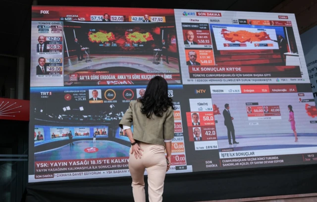 In Ankara, a woman looks on electronic board before the release of official election results at CHP's headquarters in the Turkish capital